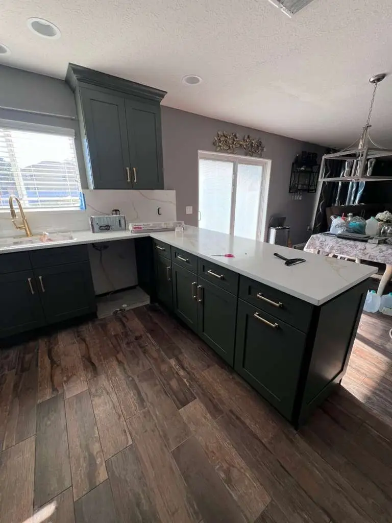 Green and white two-tone kitchen cabinets in a Tampa kitchen