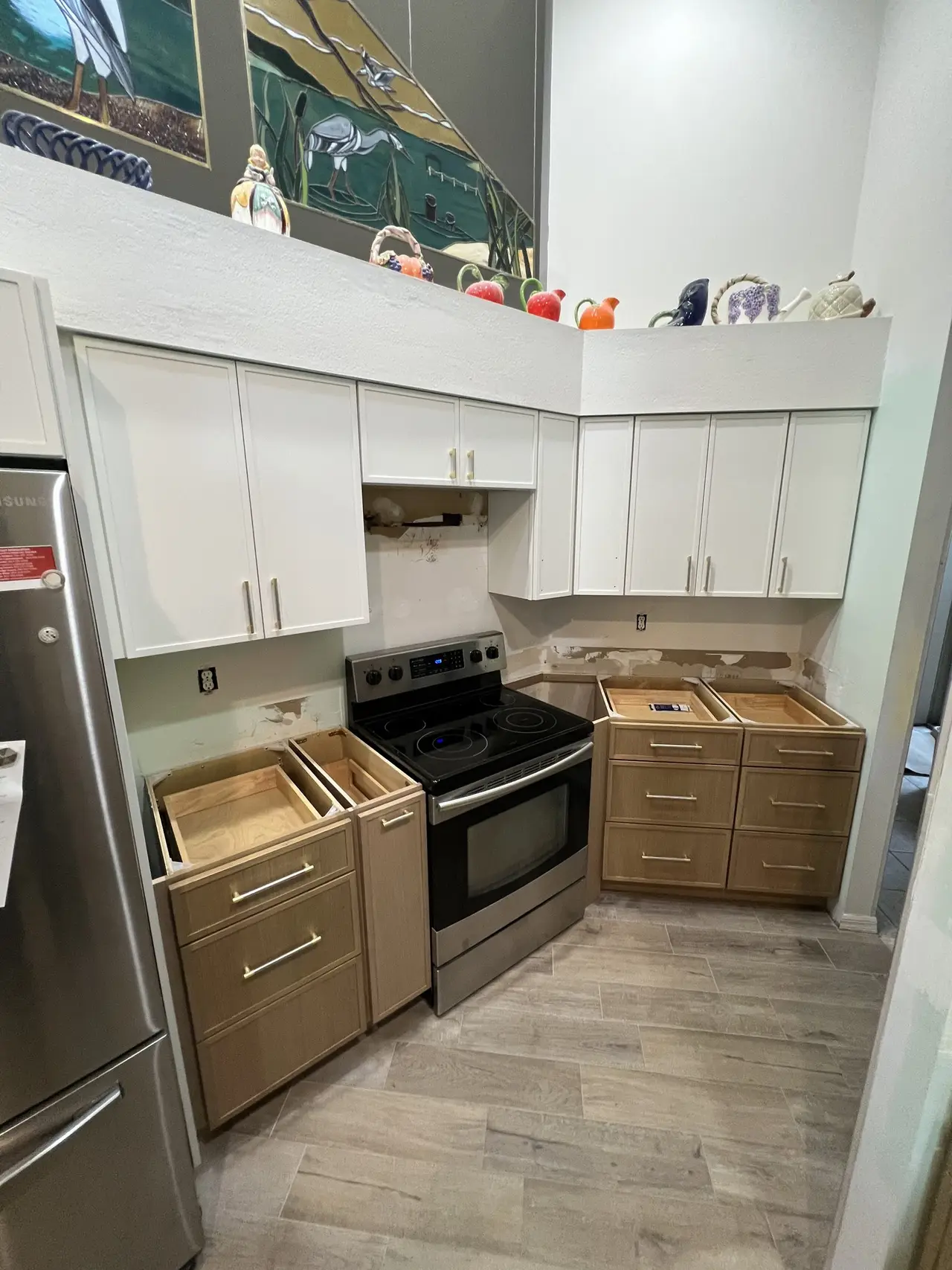 Two-tone kitchen with natural wood lower cabinets and range in Tampa